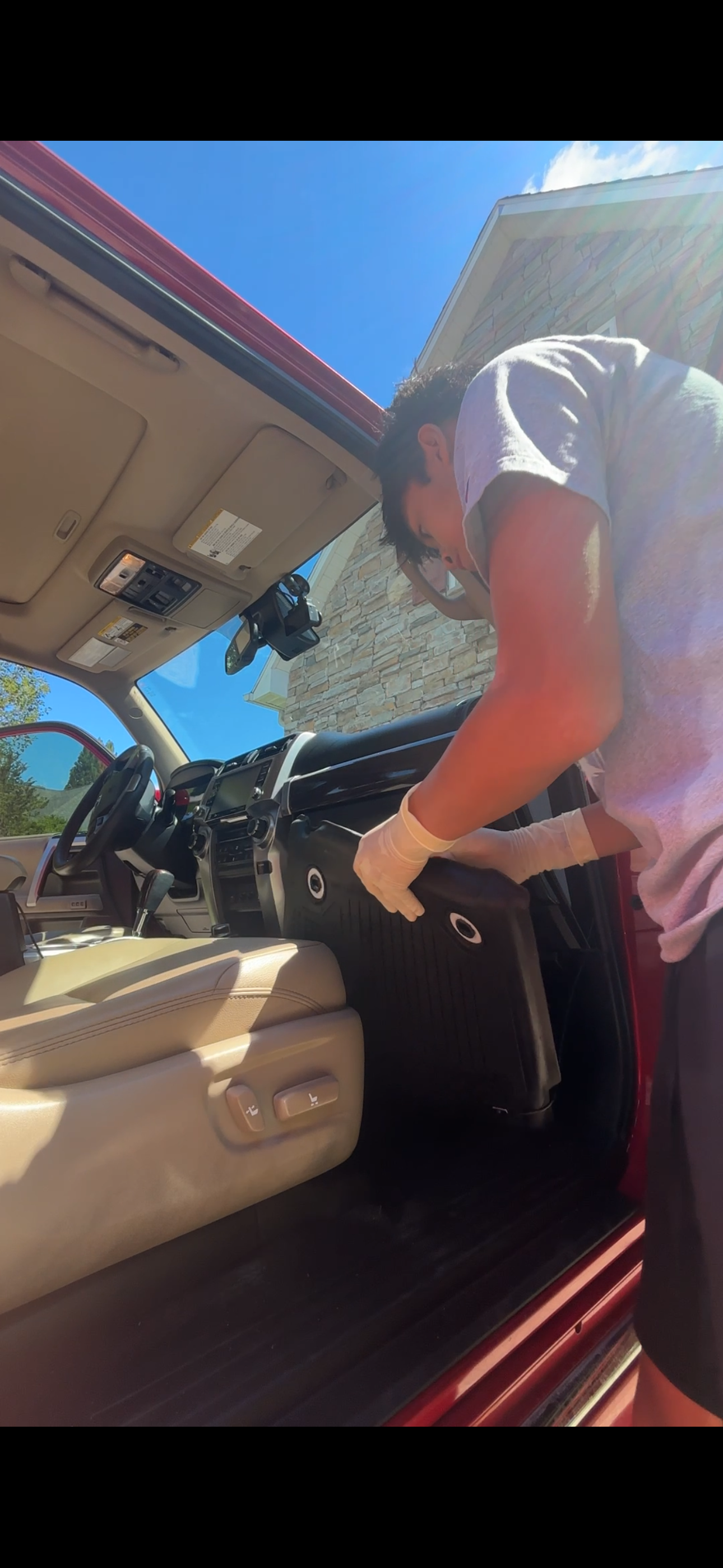 Detailer cleaning the interior floor mats of a 4Runner with gloves