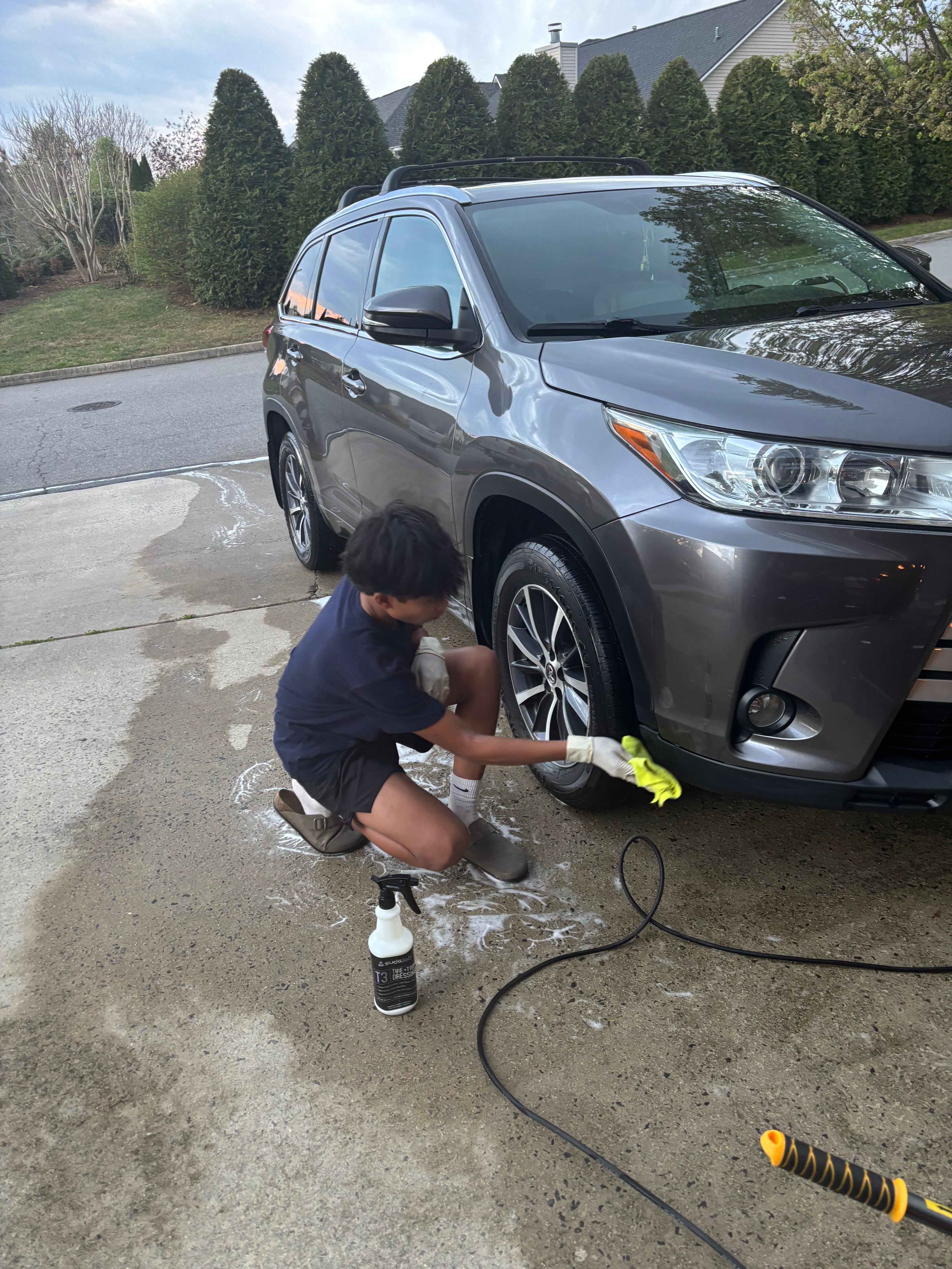 Detailer dressing the wheel and tire of a Toyota Highlander